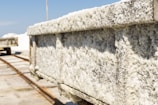 A close-up view of a salt-encrusted cart that appears to be on tracks, used for transporting salt. The cart is heavily coated with white salt crystals, suggesting an industrial or natural salt harvesting area.