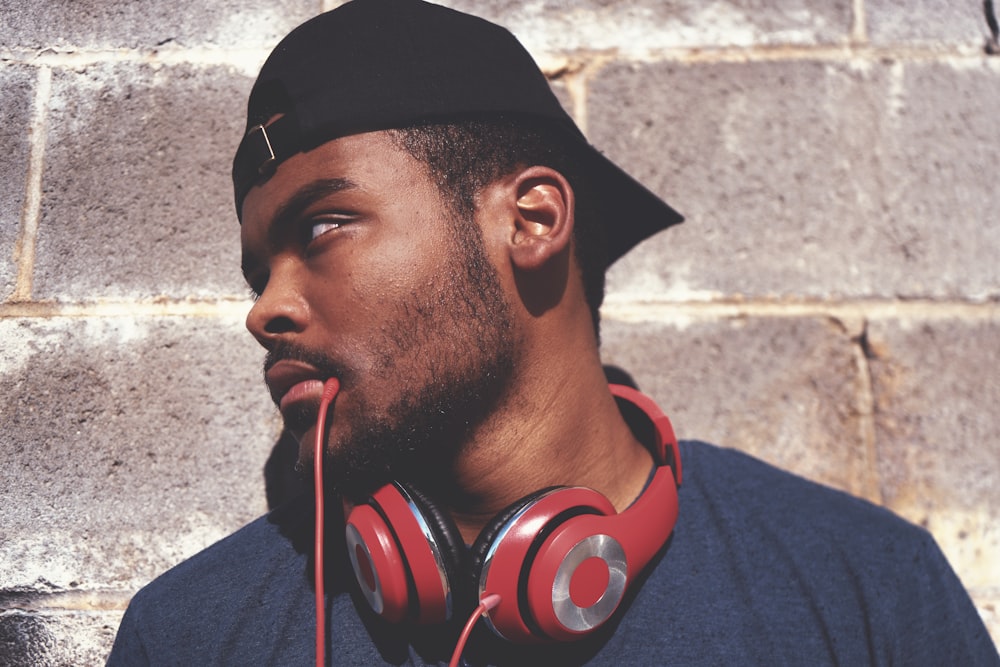 man in blue shirt with red corded headphones