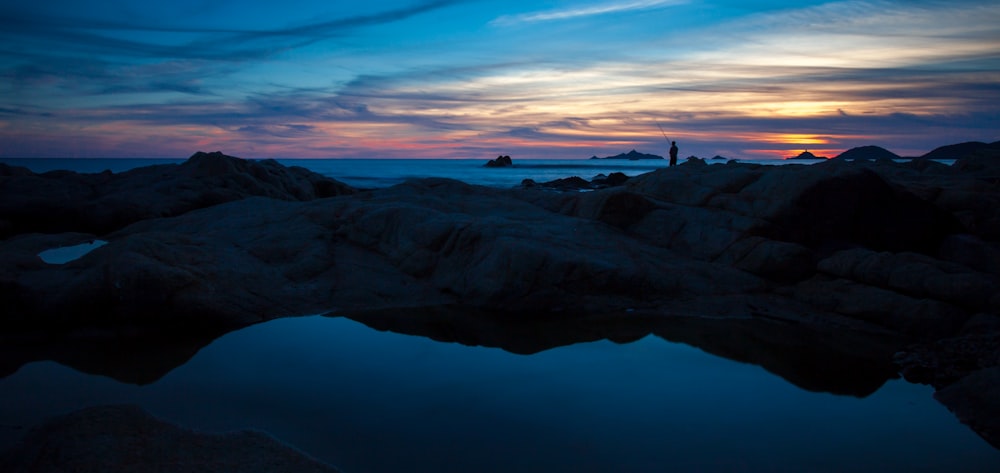 photographie de paysage de plan d’eau avec des rochers