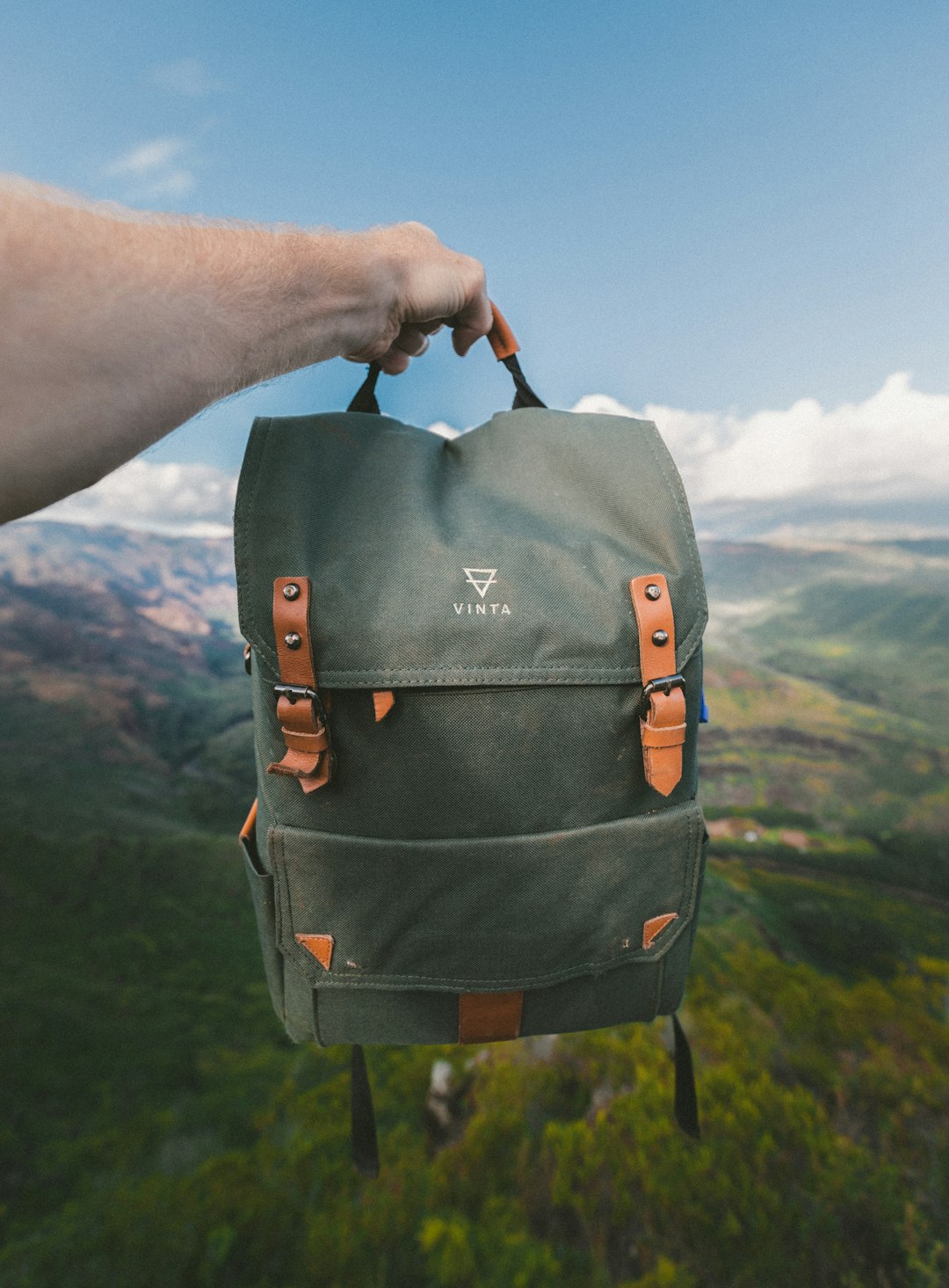 person holding black and brown Vinta backpack