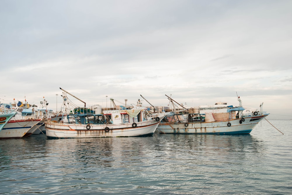 white fishing boars on body of water