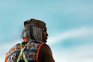 A close-up portrait of a smiling local artisan in traditional attire, with vibrant island colors in the background.