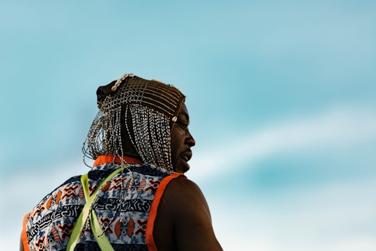 A close-up portrait of a smiling local artisan in traditional attire, with vibrant island colors in the background.