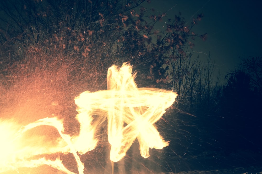 photo timelapse de la personne faisant étoile à l’aide du feu