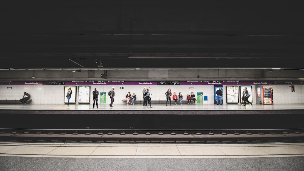 people standing and walking in train station