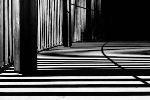 pillar of building shadows grayscale photography