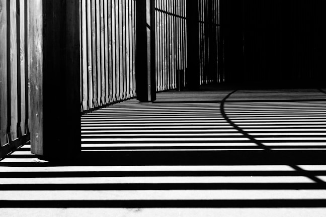 pillar of building shadows grayscale photography
