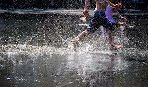 A joyful moment of kids splashing in a shallow lake, laughter and water droplets everywhere