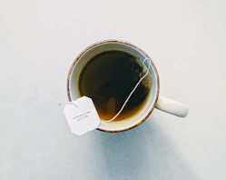 white and red ceramic mug filled with tea