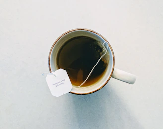 white and red ceramic mug filled with tea