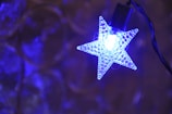 A custom blue neon light shaped like a star hanging in a cozy room.