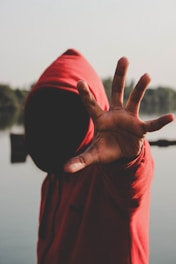 shallow focus photography of person in red hooded jacket