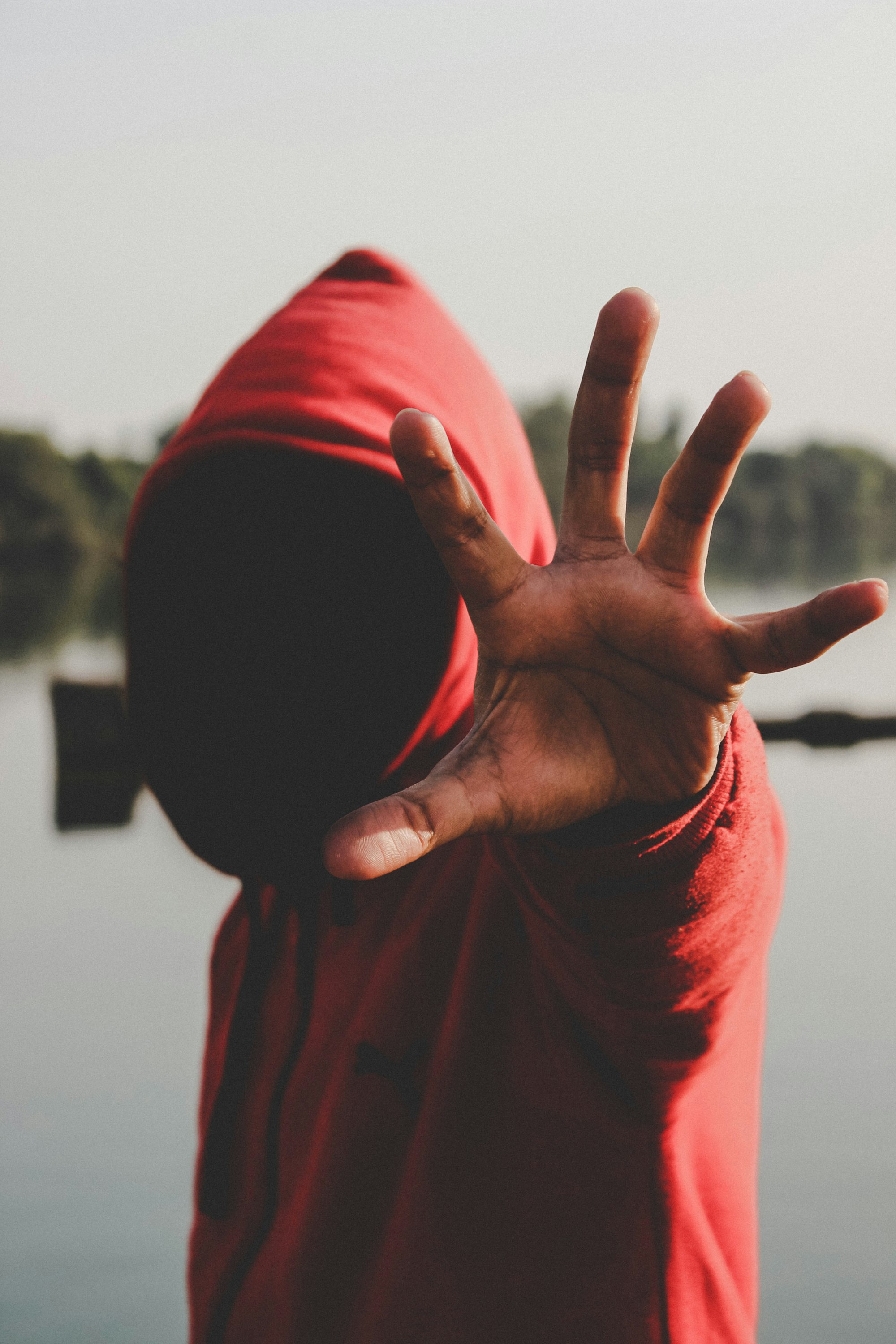 Man in hood stretching hand