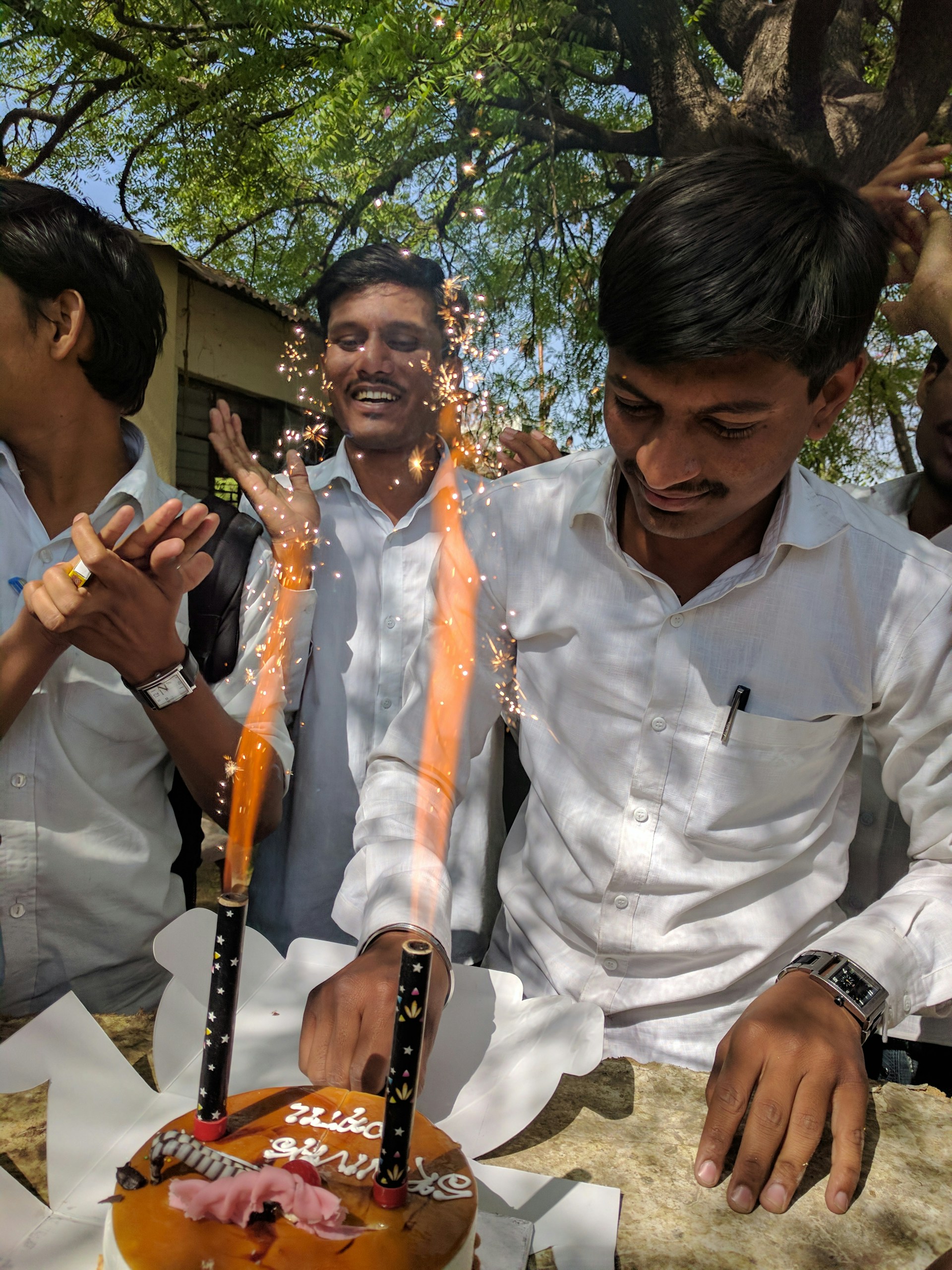 A joyful family celebrating a birthday party outdoors with speakers and festive decorations.