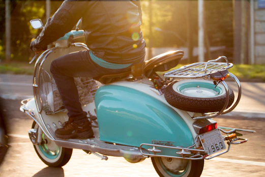 Riders in retro gear cruising along a coastal road on their Lambrettas.