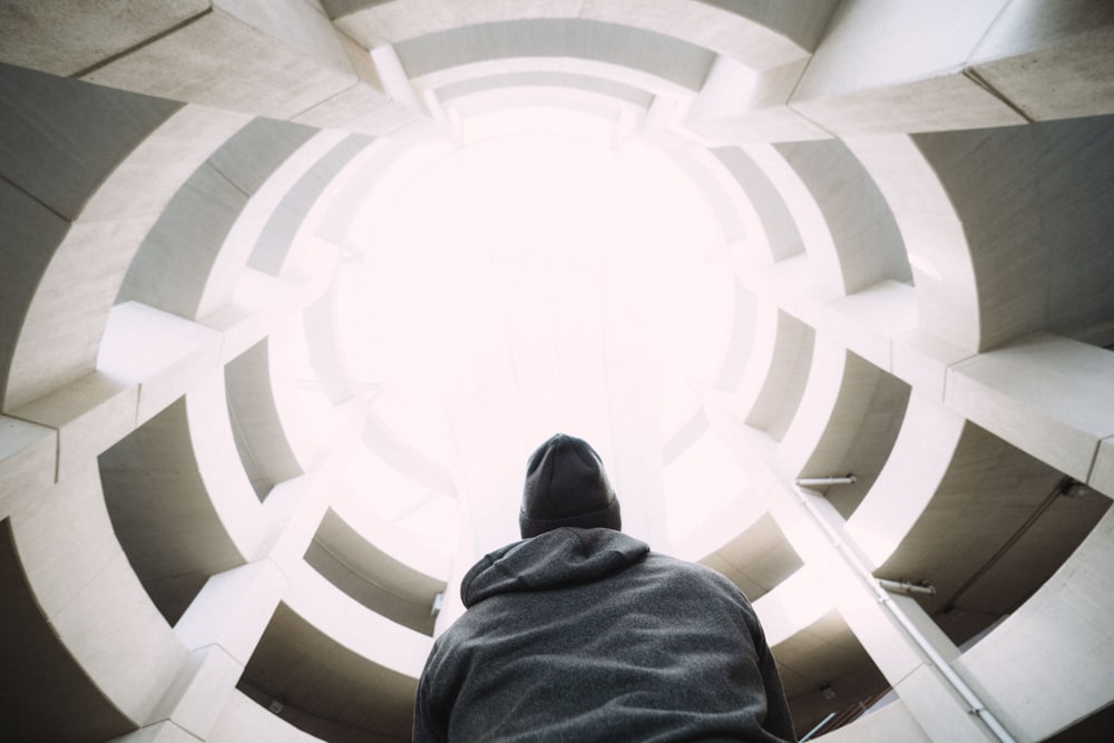 photography of person wearing gray hooded jacket inside building during daytime