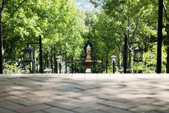 A serene temple pathway lined with lanterns glowing softly at dusk.