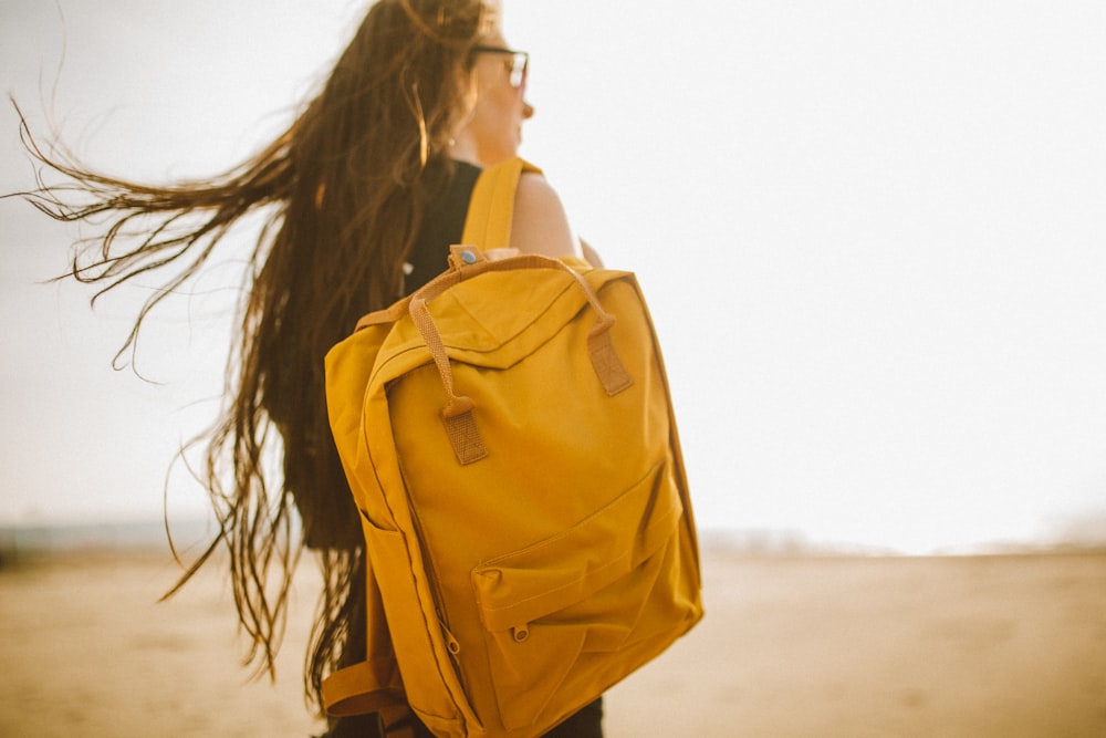 A woman carrying a yellow backpack on her back in Weston-super-Mare