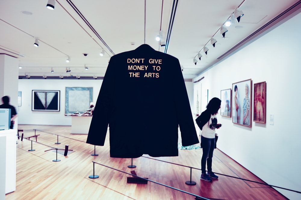 Slogan de texto ouro na jaqueta de reforço na Galeria de arte com mulher de arte, Galeria Nacional de Singapura
