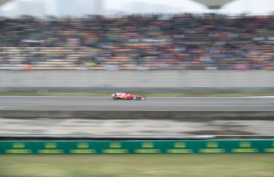 A thrilling Formula 1 car speeding on a racetrack at sunset.