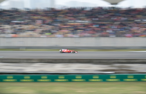 A dynamic shot of a red Ferrari on a racetrack.