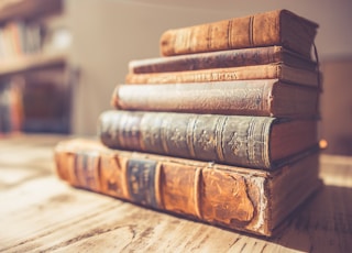 stack of six brown hardbound books