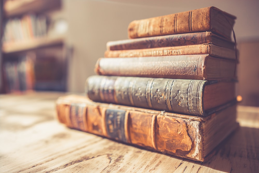 stack of six brown hardbound books