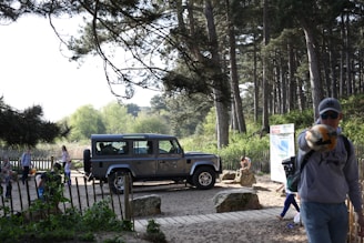 A happy family loading luggage into a spacious rental SUV at a scenic countryside location.