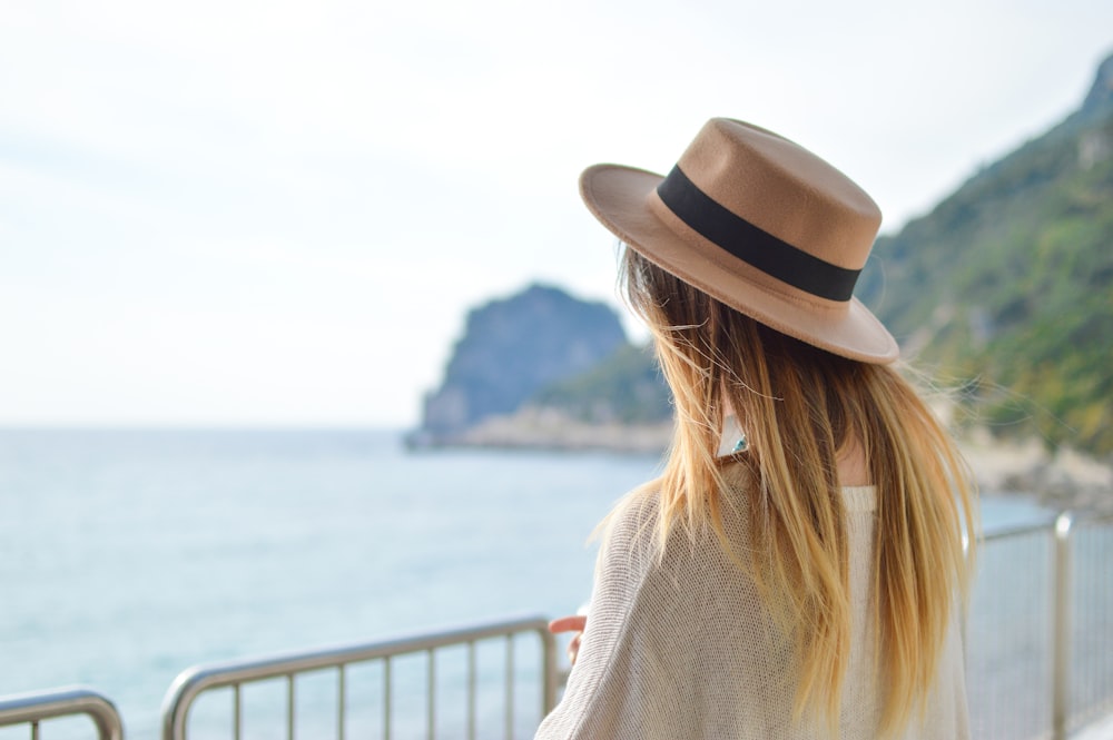 woman standing near body of water at daytime