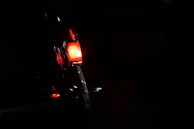 An antique car’s headlight glowing softly against a dark, rustic backdrop.