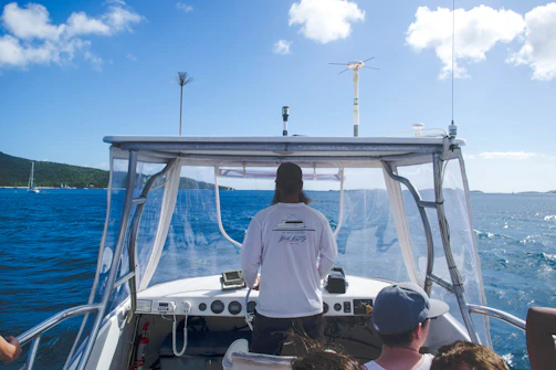 A student learning to navigate with the instructor pointing towards the horizon on a bright day.