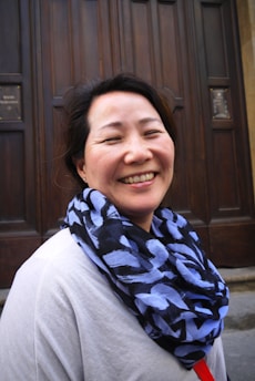 A welcoming host opening their home door with a smile.