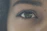 Close-up of a person holding a smartphone capturing a clear iris photo with side lighting.