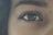 Close-up of a person holding a smartphone capturing a clear iris photo with side lighting.