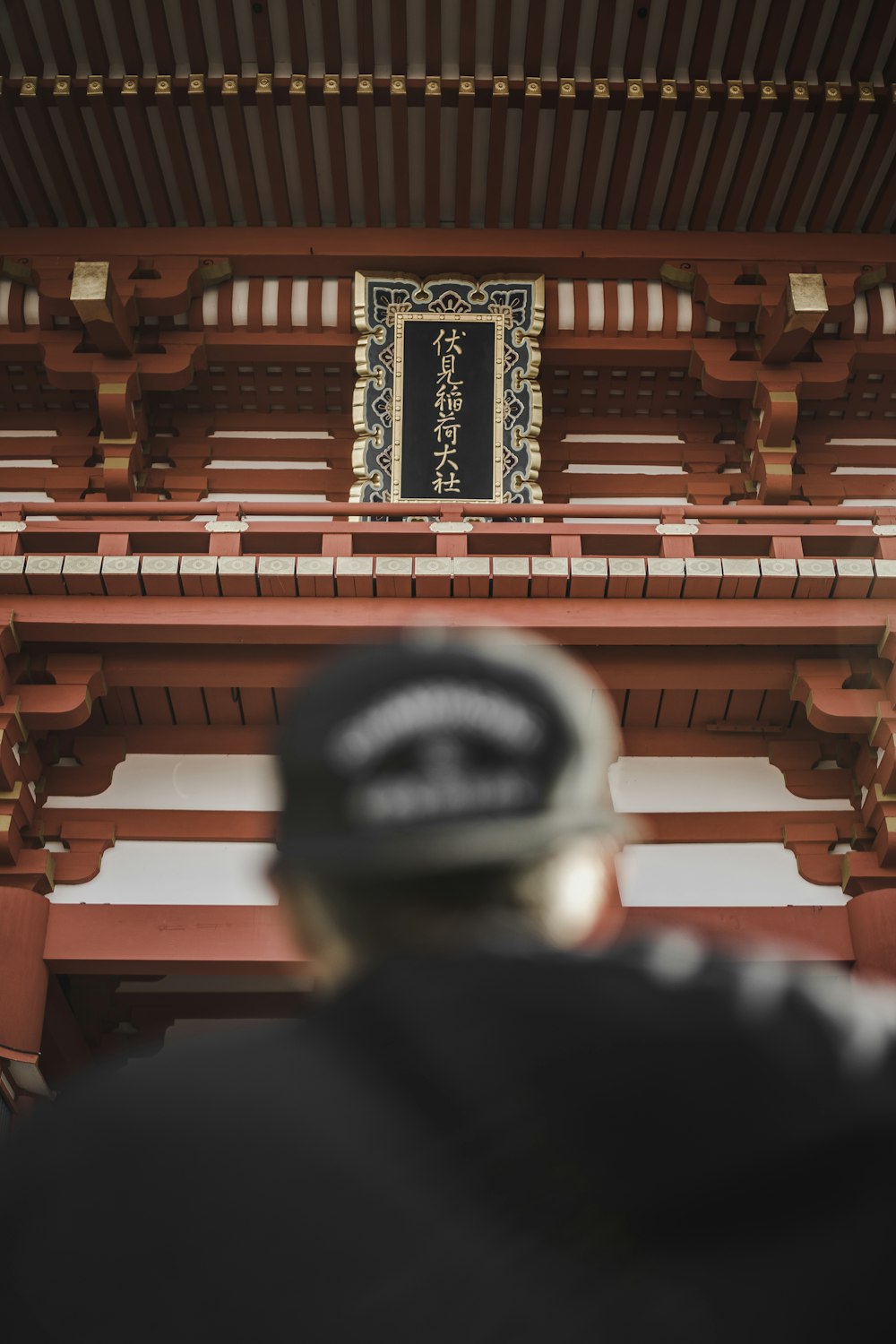 person wearing black cap in front of tower