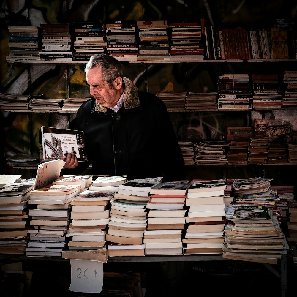 man holding book near library