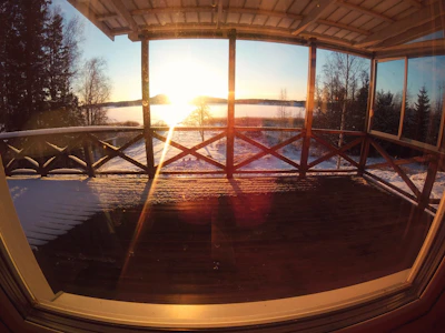 Bright custom aluminum veranda glowing softly under a clear blue sky at sunset