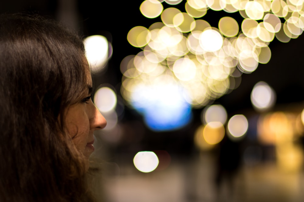 woman facing boke lights
