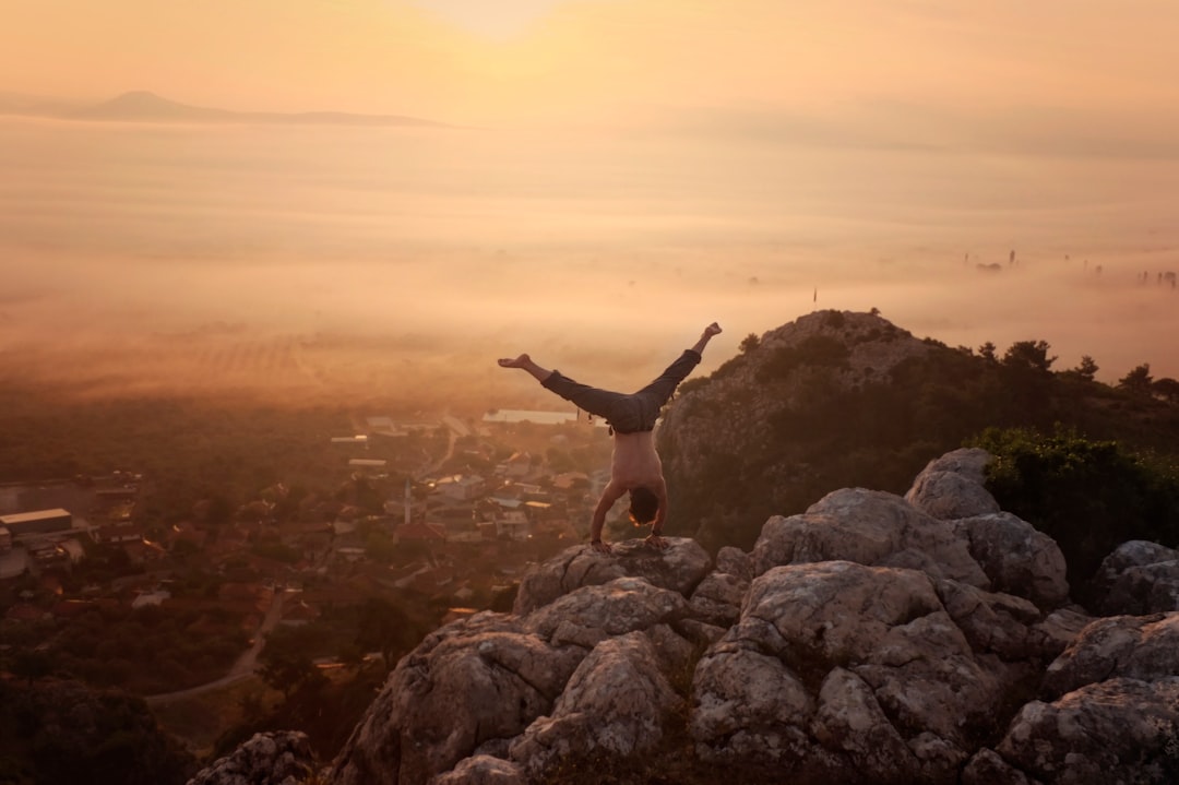 man doing handstand on boulders