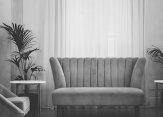 grey couch near white window curtain during daytime