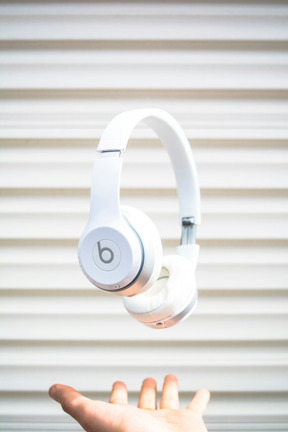auriculares blancos Beats by Dr. Dre en el aire