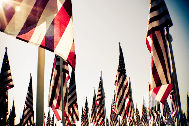 A warm photo of veterans sharing a friendly moment at a community event under a waving American flag.