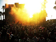 Joyful expressions of people celebrating outdoors during a sunset event.