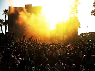 A vibrant photo capturing a lively crowd at a sunset outdoor event.