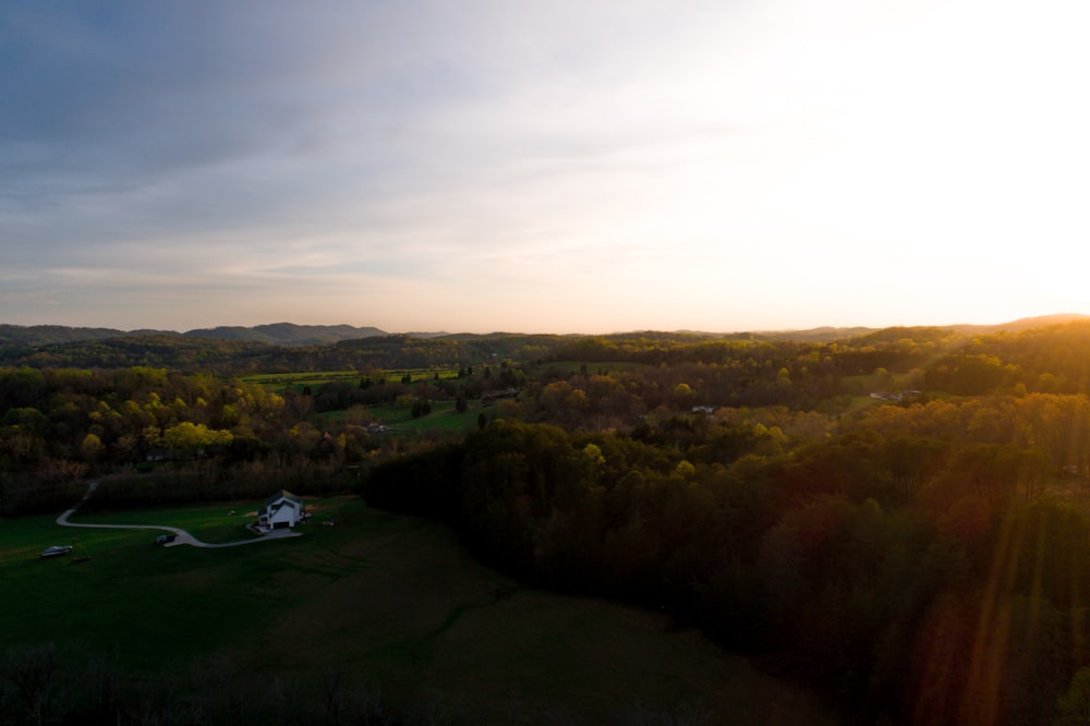 an aerial view of a field with a house in the distance