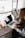 girl wearing grey long-sleeved shirt using MacBook Pro on brown wooden table