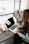 girl wearing grey long-sleeved shirt using MacBook Pro on brown wooden table