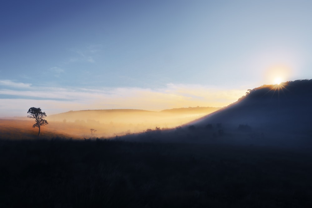 silhouette photography of mountain under blue sky