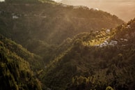 Sunset view of a mountain village with terraced fields glowing in golden light.