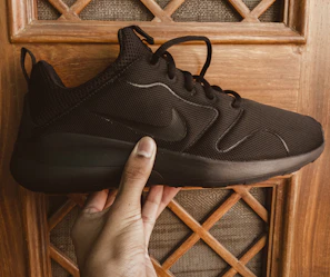 A designer sketching new shoe concepts with samples of athletic shoes nearby